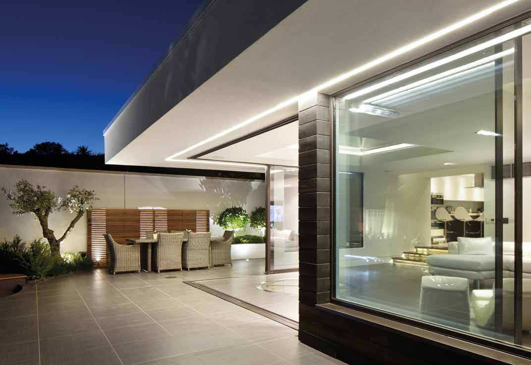 Illuminated sliding glass doors viewed from the terrace at night