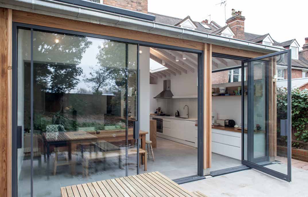 Open sliding doors beside a dining room and terrace